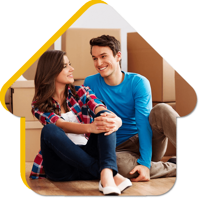 A man and woman sitting on the ground in front of boxes.