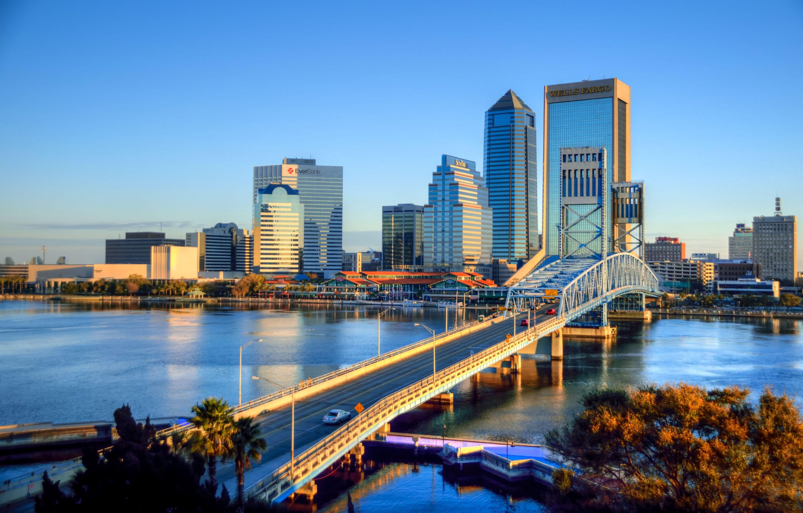 A bridge over the water with buildings in the background.